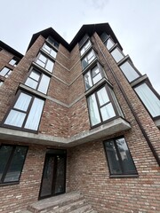 Naklejka premium Modern Brick Apartment Building with Large Windows