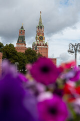 Kremlin tower behind vibrant flowers at Red Square in Moscow