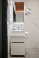 Faucet with ceramic sink and mirror in the bathroom