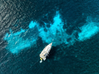 Aerial view of a yacht anchored in the crystal-clear turquoise waters off Mallorca, Balearic...