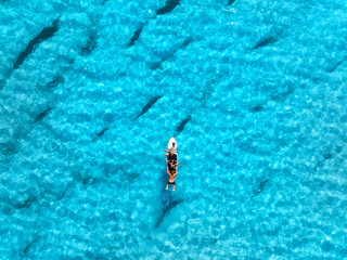 Aerial view of sup board and blue sea with transparent water on summer sunny day . Top drone view...