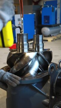 Technician placing screw compressor rotor into housing