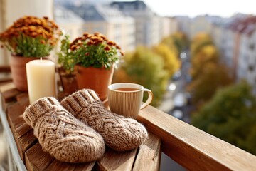Fototapeta premium Cozy urban balcony adorned with candles, a warm drink, and footwear, perfect for relaxation