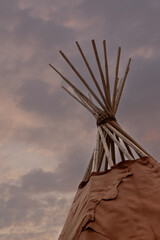 Teepee and cloudy sky on background