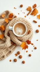 Warm coffee mug wrapped in a scarf with fallen foliage and spices on a plain neutral surface
