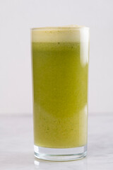 Green detox drink in crystal glass on white background - Fresh detox juice in decorative glass - Clean eating concept with green juice