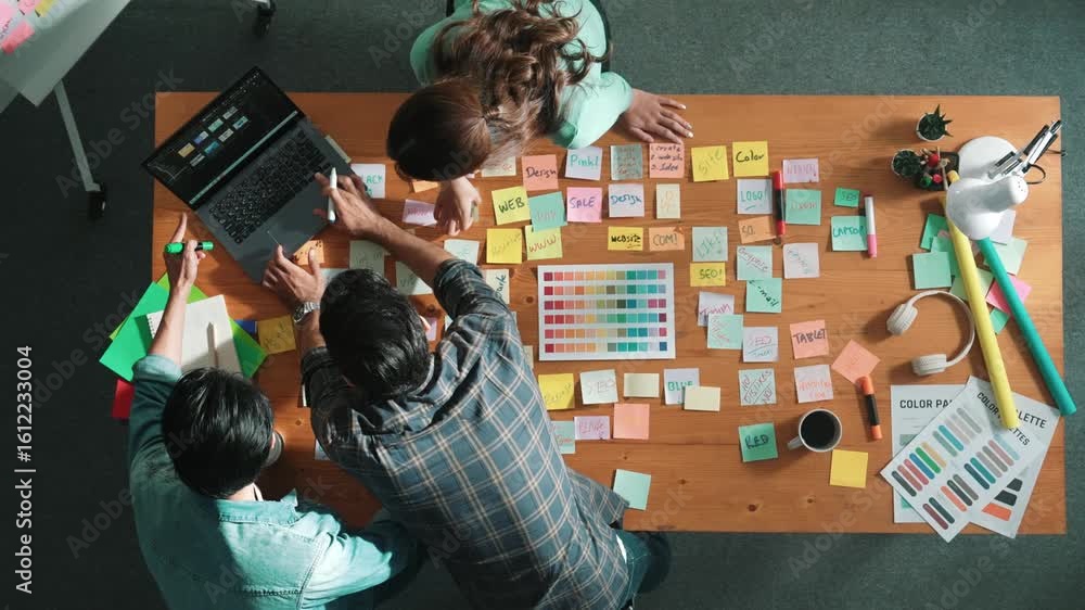 Poster top down view of business team with casual outfit looking laptop screen and sharing idea. aerial vie