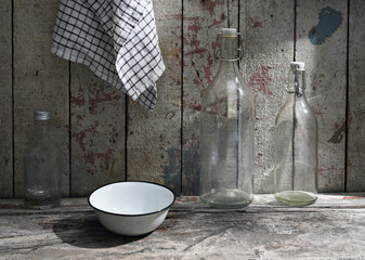 Rustic Kitchen Scene with Glass Bottles and Enamel Bowl