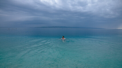 Man swimming in turquoise Adriatic Sea in Croatia