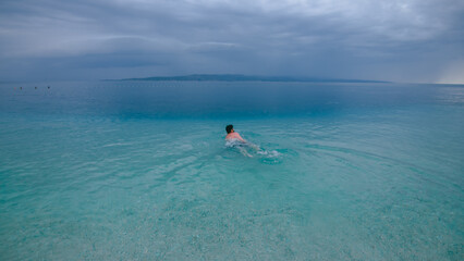 Man swimming in turquoise Adriatic Sea in Croatia