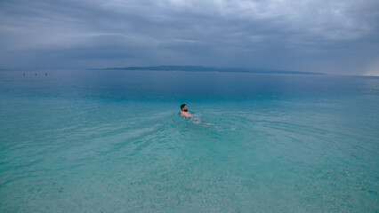 Man swimming in turquoise Adriatic Sea in Croatia
