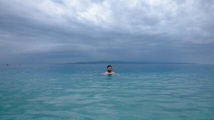 Man swimming in turquoise Adriatic Sea in Croatia