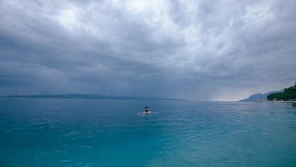 Man swimming in turquoise Adriatic Sea in Croatia