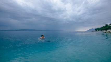 Man swimming in turquoise Adriatic Sea in Croatia