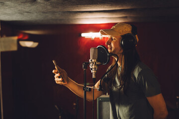 Singer recording song in professional studio using smartphone app