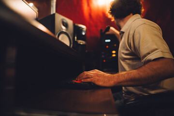 Sound engineer working in recording studio using mixing console and computer