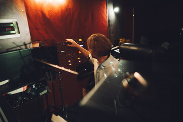 Sound engineer working at mixing console in recording studio