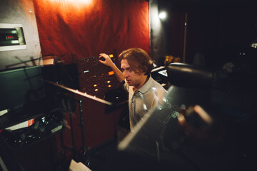 Sound engineer working in professional recording studio using a mixing console