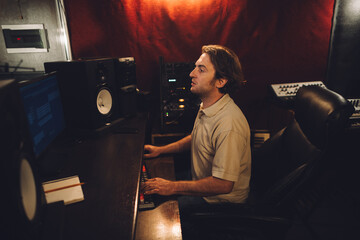 Sound engineer working in professional recording studio mixing music