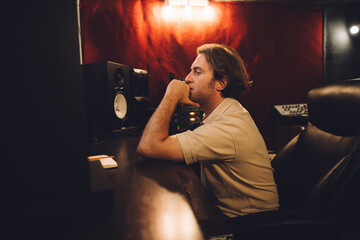 Sound engineer working and composing music in recording studio