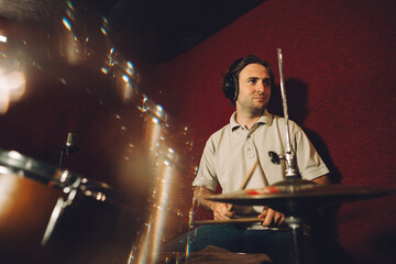 Drummer recording music in professional studio with headphones