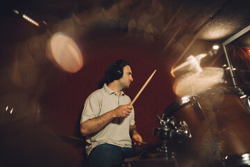 Drummer playing drums in recording studio with motion blur effect