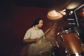 Musician playing drums inside recording studio
