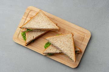 Freshly made sandwiches served on a wooden cutting board in a modern kitchen setting during daytime