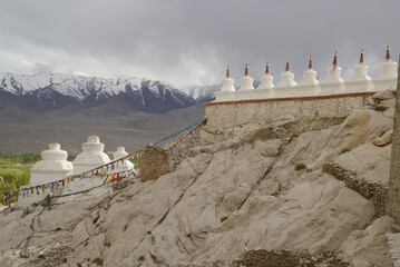 Many Buddhist white stupas and Himalayas mountains background in the Shey Palace. A famous Tibetan...