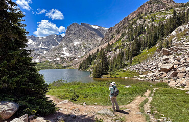 Hiker taking a photo at Isabelle Lake in Colorado's Indian Peaks Wilderness, Boulder County