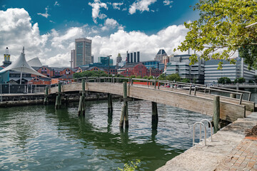 modern harbour with high rise buildings under a clear blue sky. The brick embankment and white...