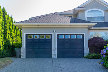 Garage door in luxury house with trees and nice landscape in Summer in Vancouver, Canada, North...