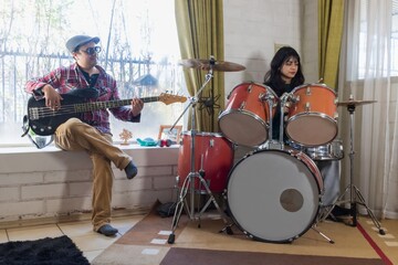 Fototapeta premium Latino father and daughter playing musical instruments