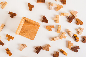 Wooden puzzles and empty collection box on light background top view