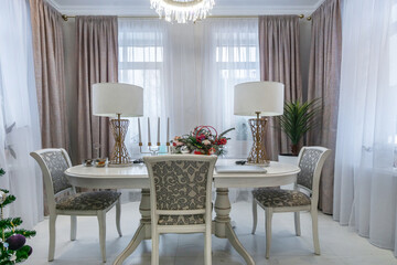 An elegant dining room with a round table and decorative Christmas decorations in a stylish...
