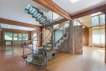 A modern living area with a spectacular glass staircase, large windows providing natural 
light,...