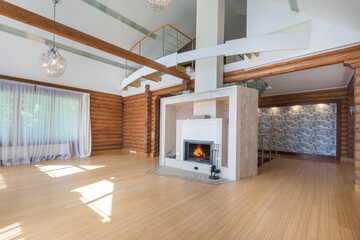 The interior of the living room is modernly designed, with wooden beams and a large fireplace,...