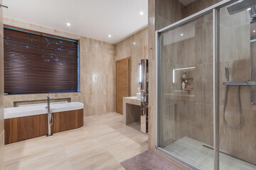 The bathroom is decorated in beige tones, with a modern design. A freestanding bathtub by the...