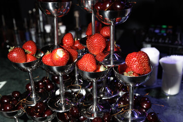  A sophisticated arrangement of fresh strawberries and cherries elegantly presented in stacked...