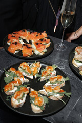  Plates of gourmet appetizers, featuring smoked salmon and shrimp on crisp bread, are served alongside a glass of champagne. The scene captures an elegant celebration atmosphere.