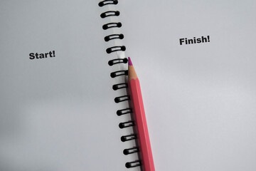 Concept of start and finish write on book isolated on Wooden Table.