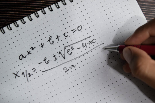 Concept of general quadratic equation write on book isolated on Wooden Table.