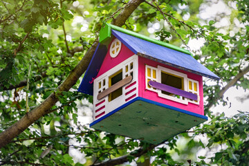 Beautiful wooden birdhouse in the green summer garden