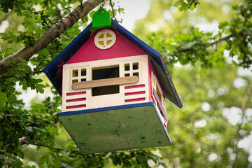 Beautiful wooden birdhouse in the green summer garden
