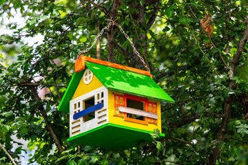 Beautiful wooden birdhouse in the green summer garden