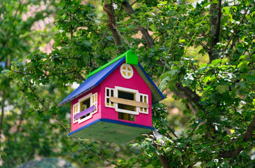Beautiful wooden birdhouse in the green summer garden