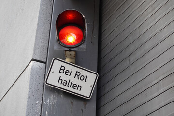 Red Traffic Light With German Words Bei Rot halten Meaning Stop at red lights In English Language.