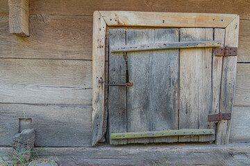 Weathered wooden door on rustic log structure in ancient Central European village, natural lighting, earth tones, no human activity