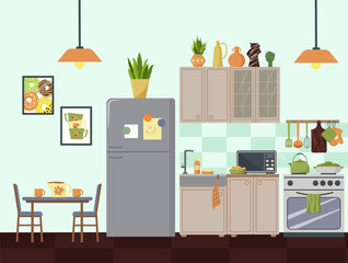 Modern kitchen interior with furniture and appliances. Table with chairs, refrigerator, cupboards for dishes and personal items. Microwave, bowl with cookies are on the table. Figurines, paintings