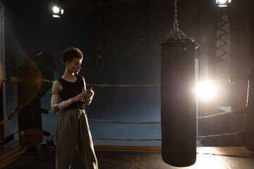 Female athlete boxing in dim gym lights, cinematic punch moment with colorful shadows
